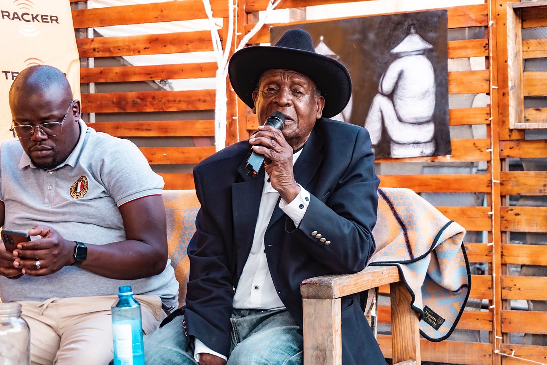 An elder speaks on the microphone at a community event